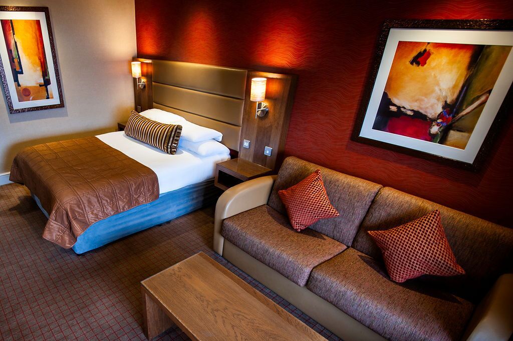 A hotel room with two beds, a sofa, and a coffee table.