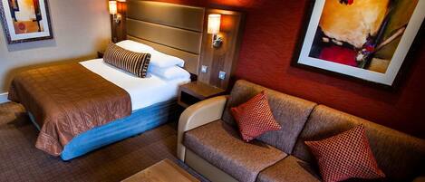 A hotel room with two beds, a sofa, and a coffee table.