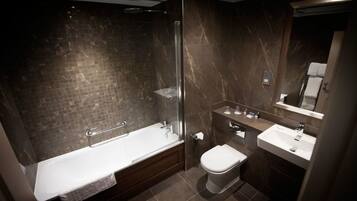 A modern bathroom with a glass-enclosed shower, a bathtub, a toilet, and a sink.