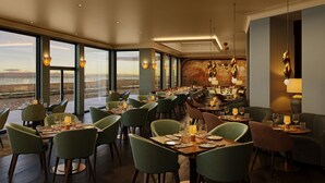 A restaurant with a view of the ocean, multiple dining tables, and chairs. - Seamill Hydro Hotel & Resort (West Kilbride)