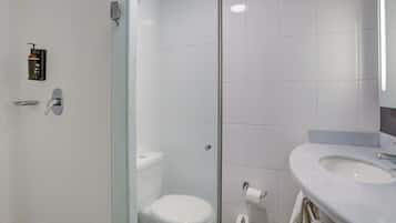 Une salle de bain moderne avec une douche à parois de verre, des toilettes blanches et un lavabo avec une serviette.