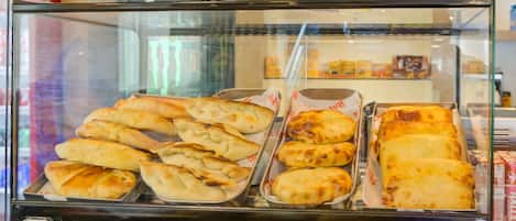 Una vitrina con diversos productos de panadería, incluyendo pan y bollería.