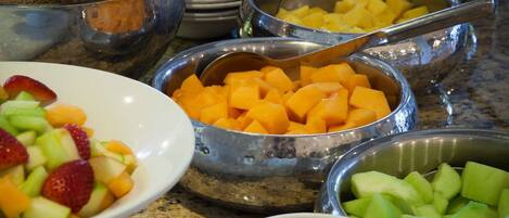 A buffet with various fruits and vegetables.