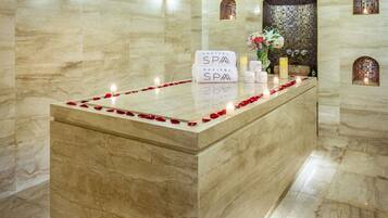 A reception area with a marble counter, a sign reading 'SOFITEL SPA,' and a decorative arrangement of candles and flowers.