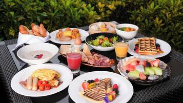 Una mesa con diversos alimentos para el desayuno, como huevos, tostadas y fruta.