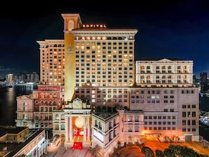 A large hotel with multiple floors, a prominent entrance with columns, and a view of the city skyline at night. - Sofitel Macau At Ponte 16 (Macau)