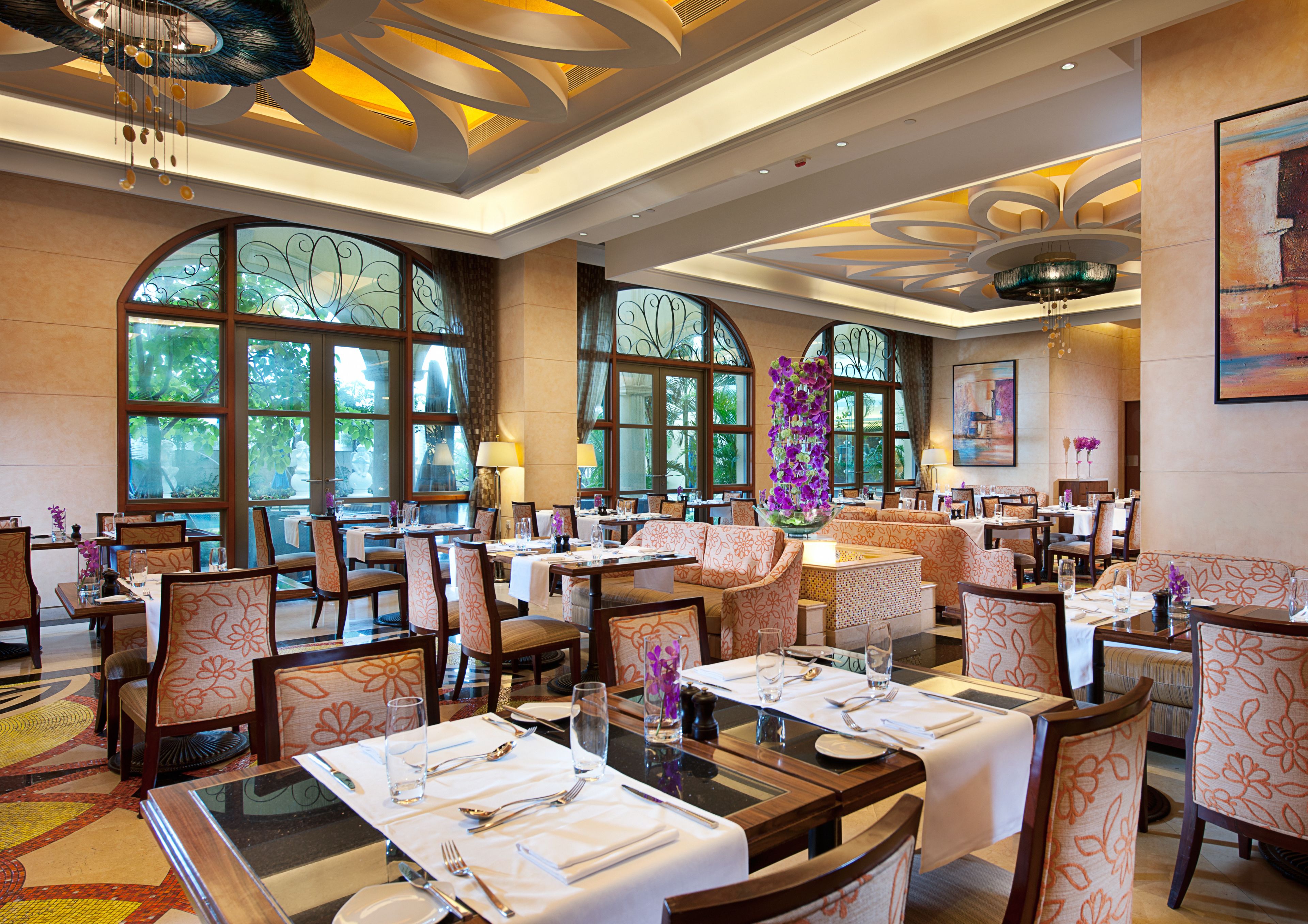 A spacious restaurant with high ceilings, large windows, and a variety of seating arrangements including tables and booths.