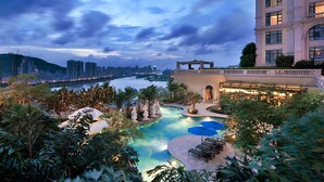 A hotel with a swimming pool, lounge chairs, and a view of the city skyline. - Sofitel Macau At Ponte 16 (Macau)