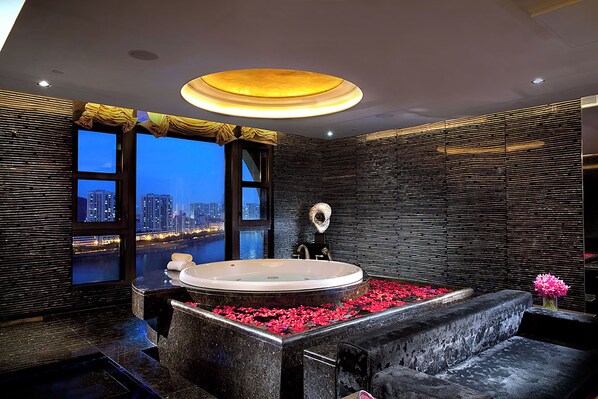 A modern bathroom with a large bathtub, a view of a cityscape, and a unique textured wall design. - Sofitel Macau At Ponte 16 (Macau)