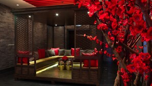 A modern interior with a sofa set, decorative panels, and a red floral arrangement. - Sofitel Macau At Ponte 16 (Macau)