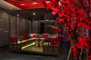 A modern interior with a sofa set, decorative panels, and a red floral arrangement. - Sofitel Macau At Ponte 16 (Macau)