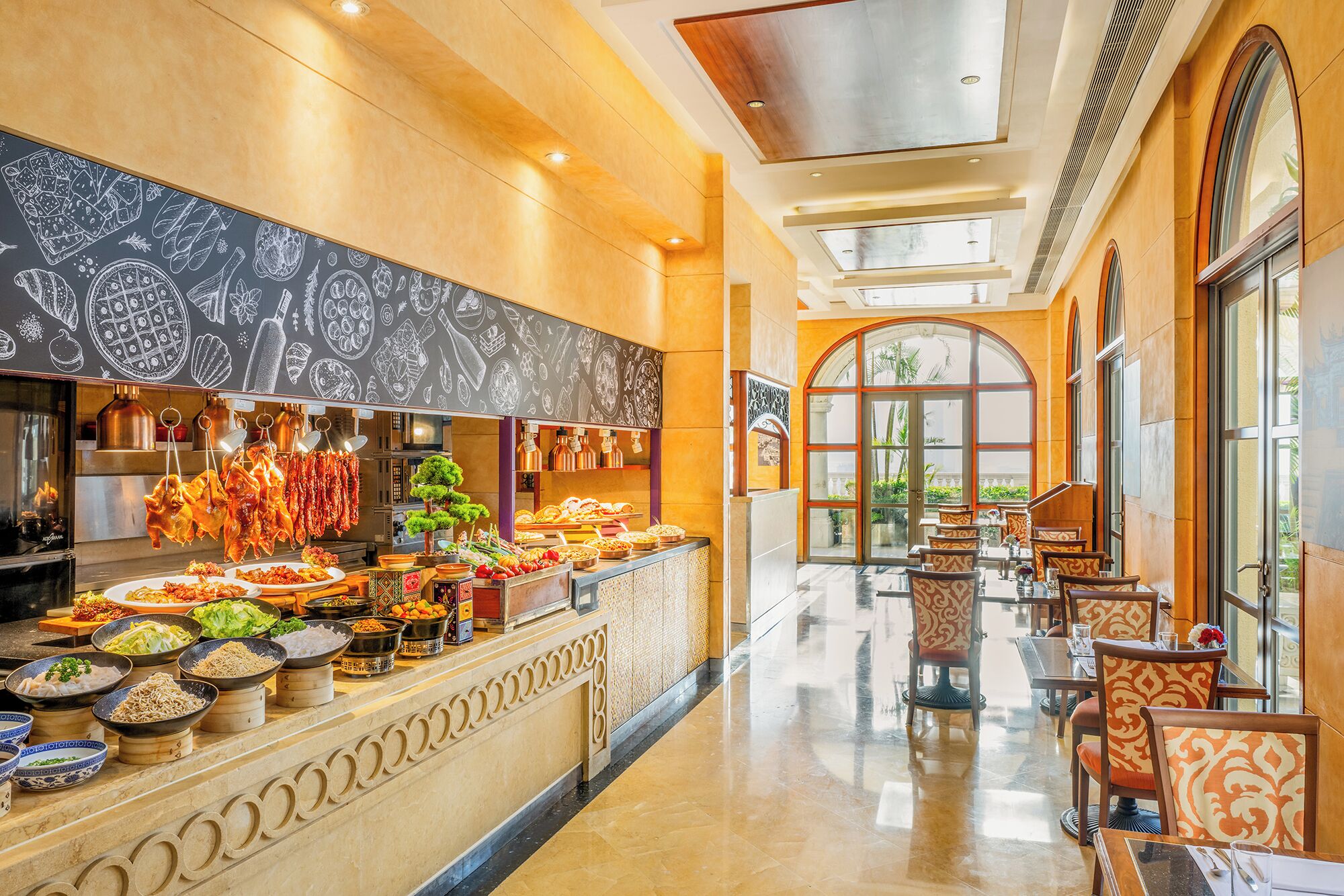 A hotel lobby with a food counter, seating area, and large windows.