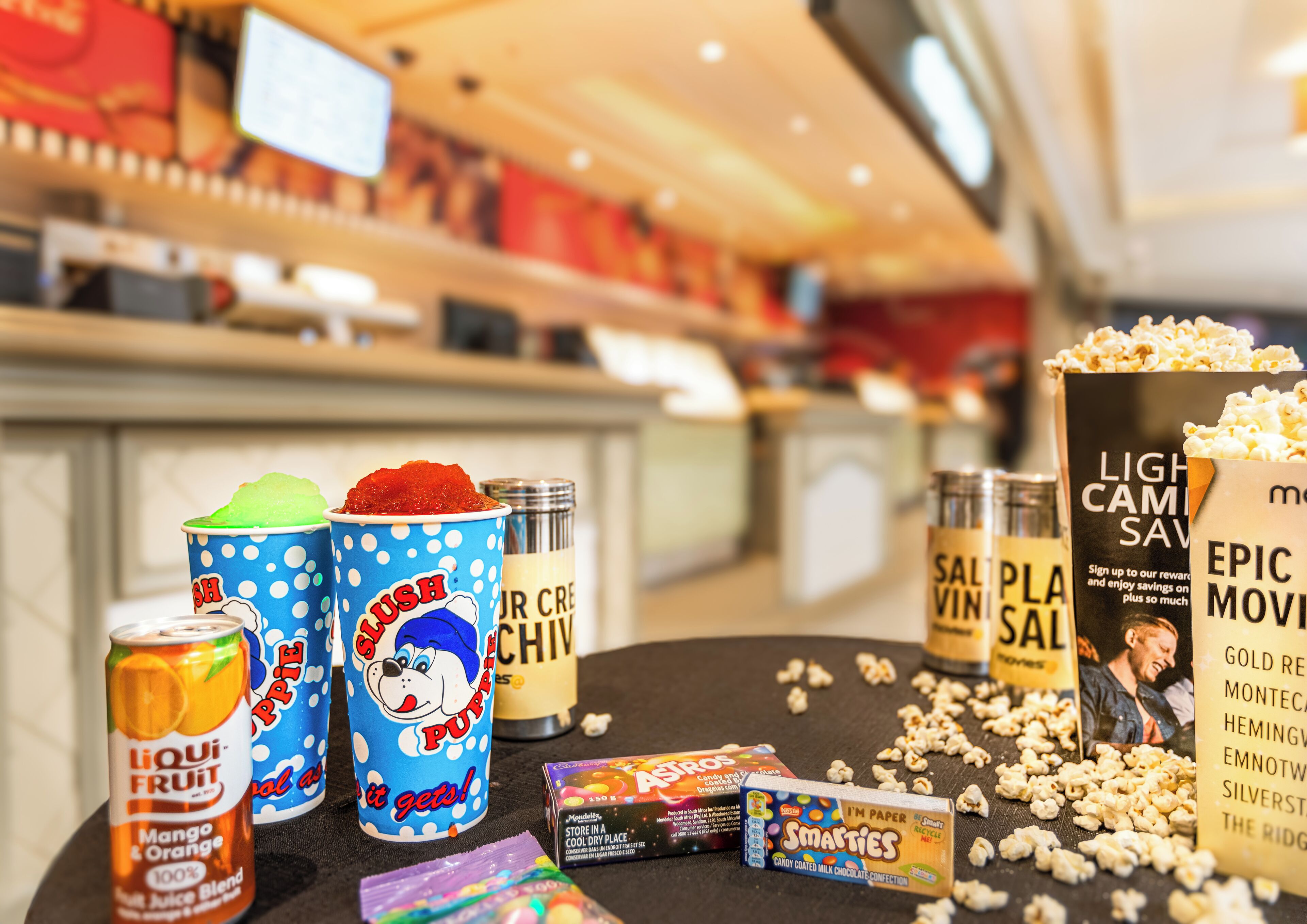 A snack bar with various food items including popcorn, candy, and drinks.