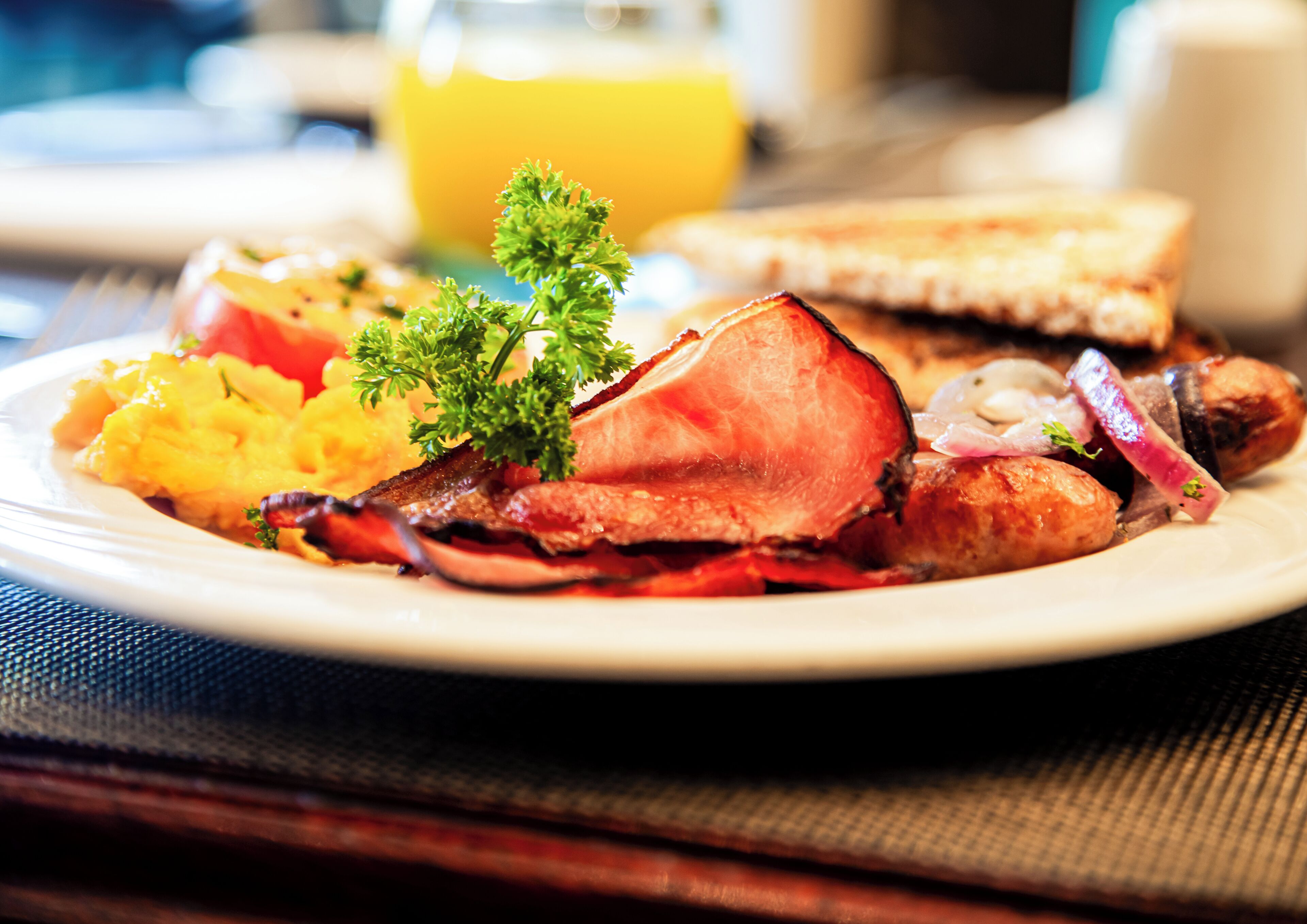 A breakfast plate with eggs, bacon, sausages, and toast.