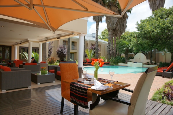 Una piscina al aire libre, sillones reclinables de piscina