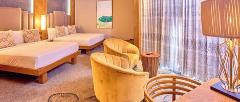 Une chambre d’hôtel avec deux lits, un canapé, une table ronde et une lampe.