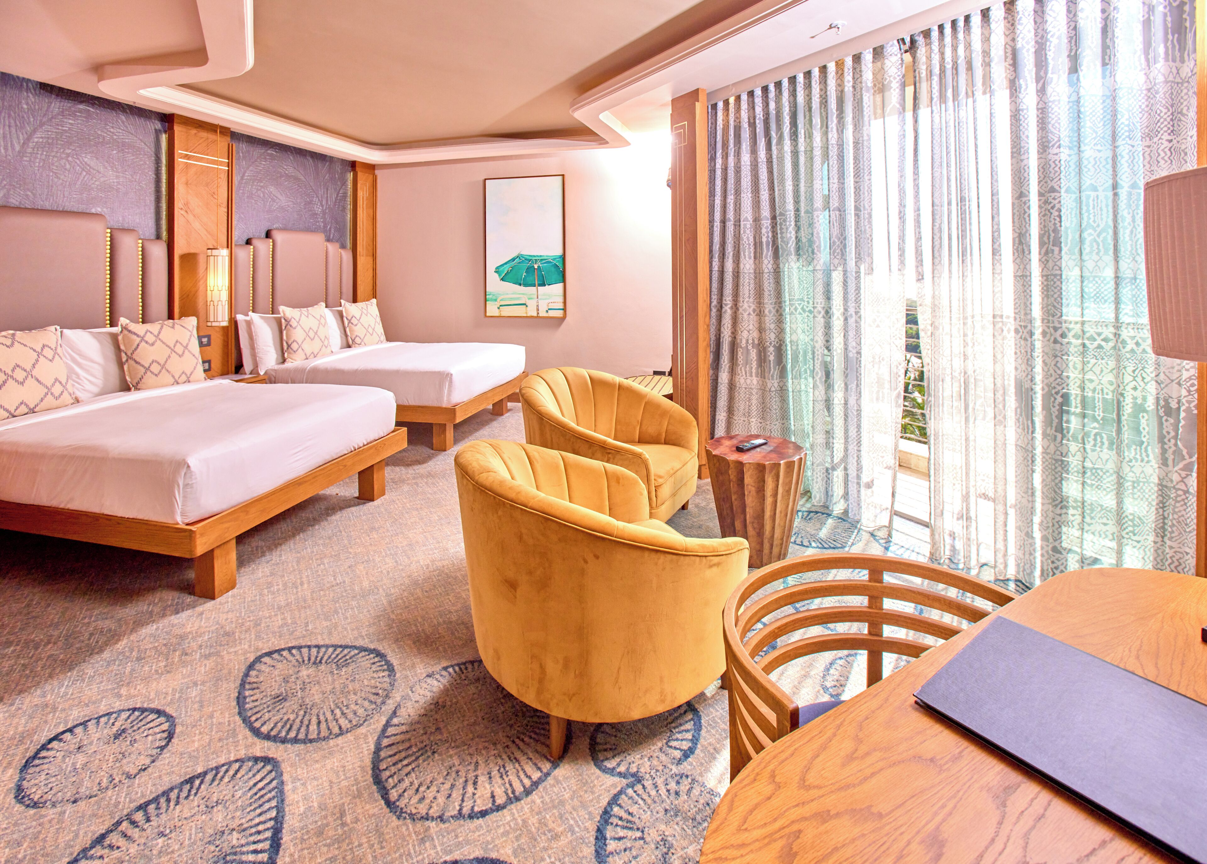 A hotel room with a bed, two armchairs, a small table, and a view of the outdoors.