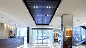A modern hotel lobby with a check-in counter, a reception desk, and a seating area. - Southern Sun Newlands (Cape Town)