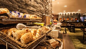 A buffet area with various breads and pastries displayed in baskets. - Southern Sun Newlands (Cape Town)