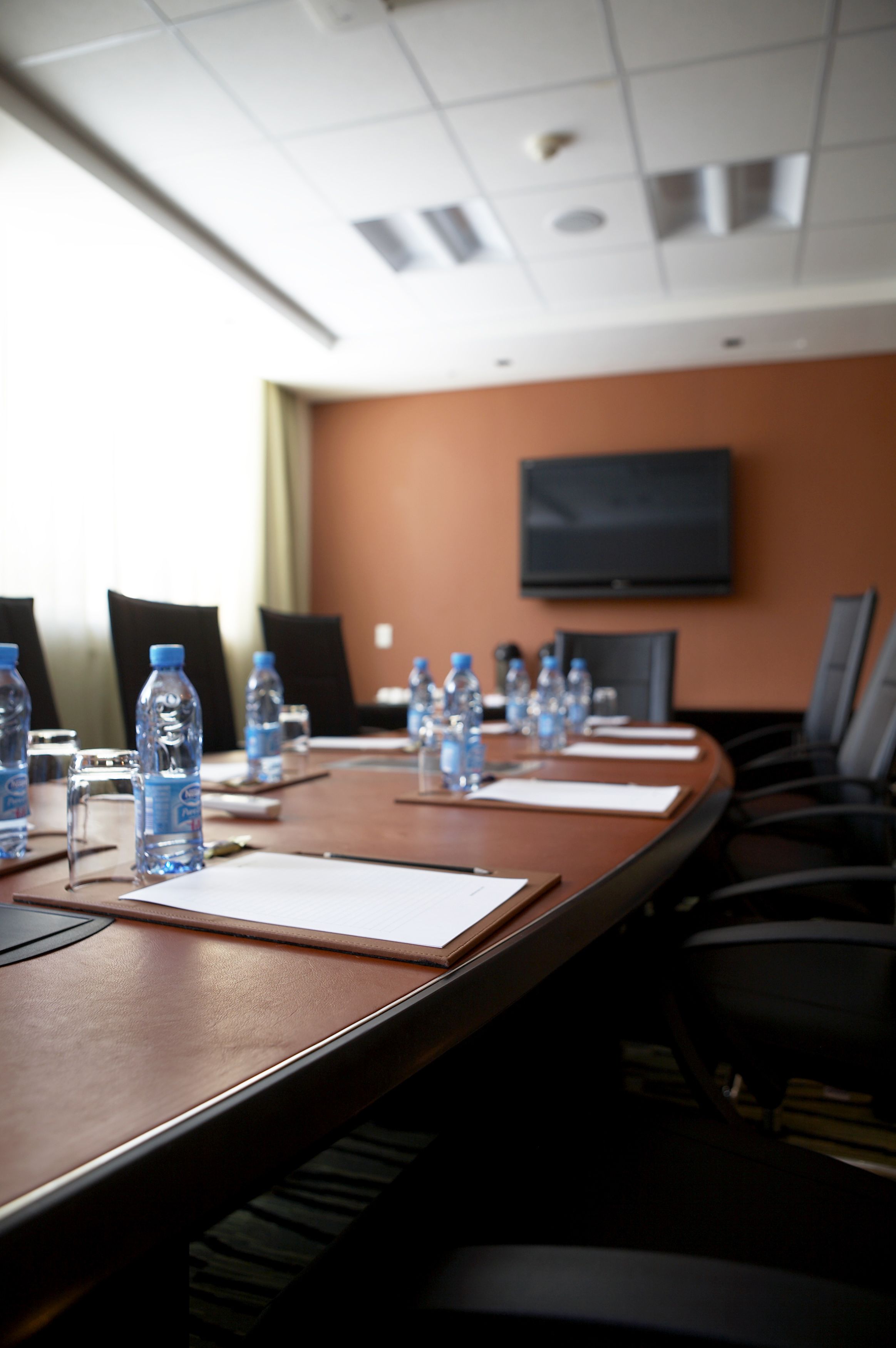 A conference room with a long table, water bottles, and chairs.