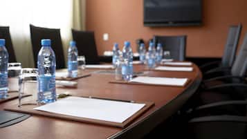 A conference room with a long table, water bottles, and chairs.