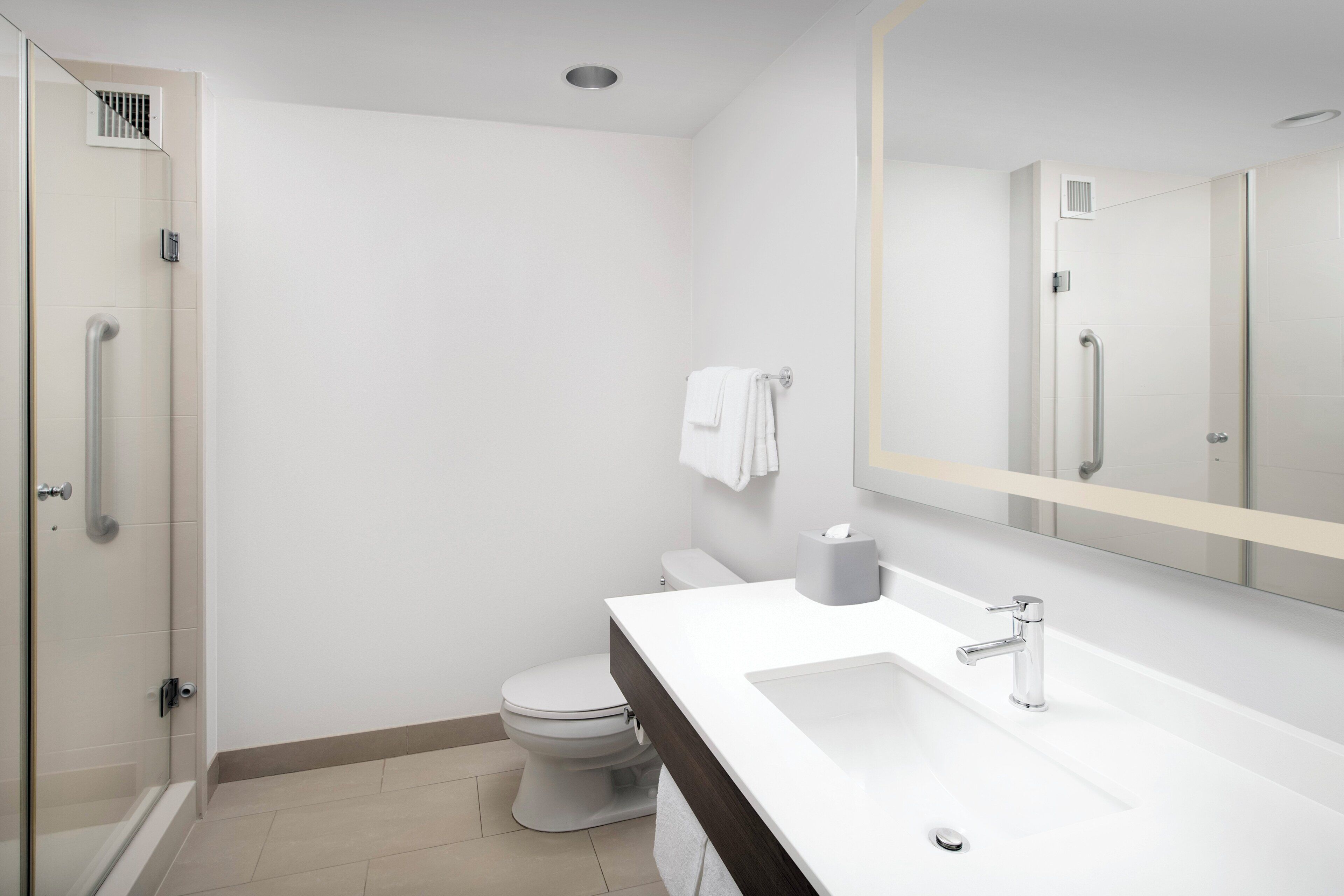 Une salle de bain moderne équipée d’une douche, de toilettes et d’un lavabo.