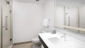 A modern bathroom with a shower, toilet, and sink.