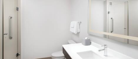 A modern bathroom with a shower, toilet, and sink.