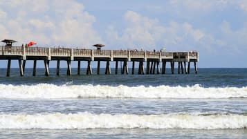 A pier extending into the water with multiple levels, some with umbrellas.