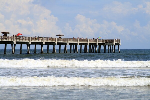 A pier extending into the water with multiple levels, some with umbrellas. - Holiday Inn Express Jacksonville Beach by IHG (Jacksonville Beach)
