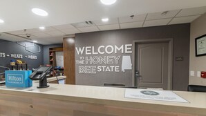 A reception area with a 'Welcome to the Honey Bee State' sign, a Hilton Honors sign, and a 'Team Members' sign. - Hampton Inn & Suites Florence-Downtown (Florence)