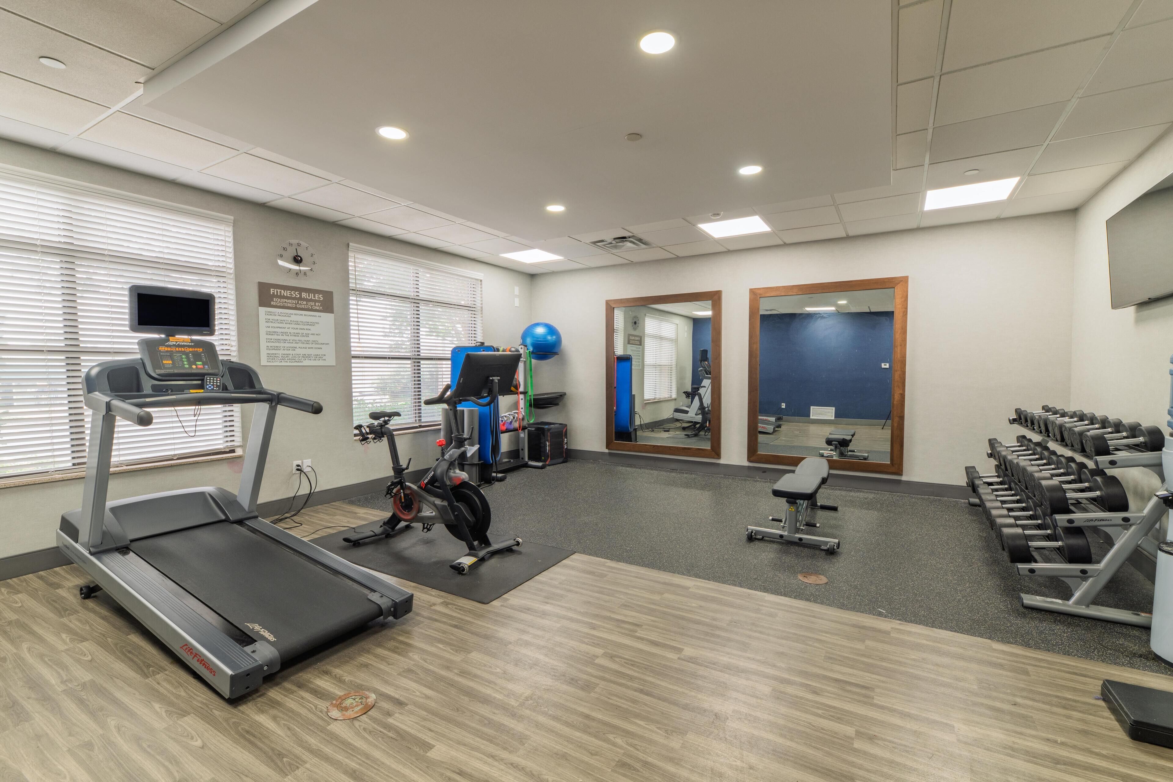A gym with treadmills, exercise bikes, and weight machines.