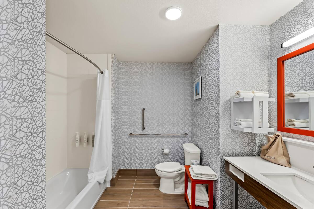 A modern bathroom with a shower, toilet, and sink.