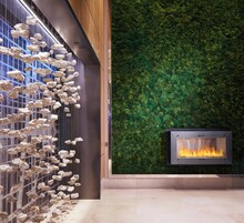 Un interior moderno con chimenea empotrada en la pared y una instalación decorativa de rocas.