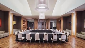 A conference room with a long table, chairs, and a modern chandelier.