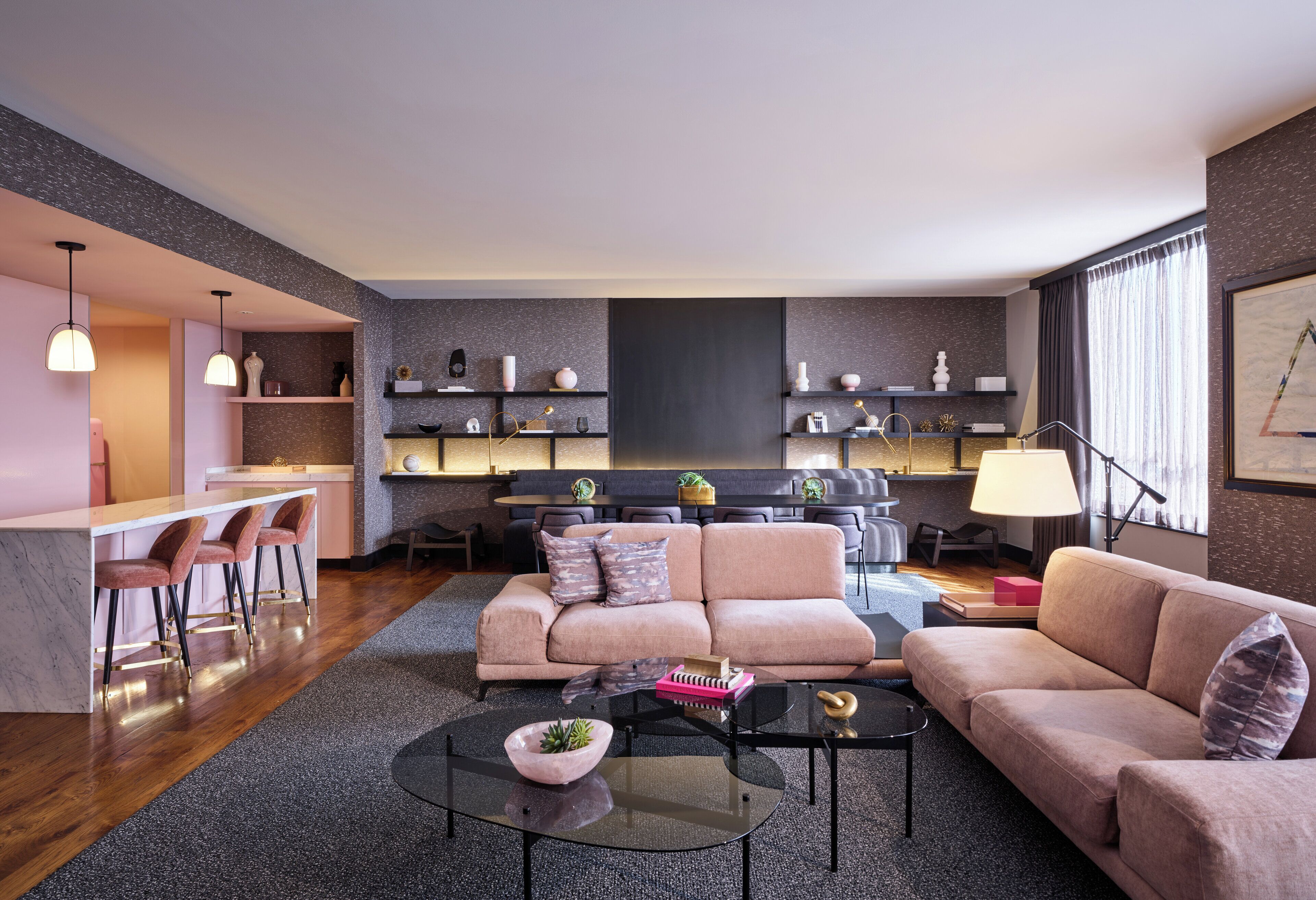 Ein modernes Wohnzimmer mit einer Couch, einem Couchtisch und einer Bar mit Hockern.