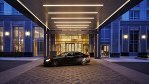 A modern building entrance with a car parked in front.