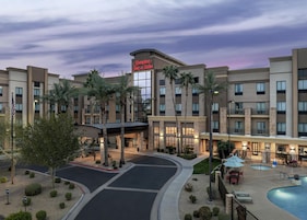 Ein Hampton Inn & Suites Hotel mit Pool, Außenbereich und Palmen.