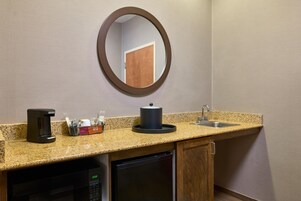Una kitchenette equipada con cafetera, microondas, pileta y heladera pequeña.