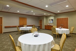 A hotel conference room with multiple round tables, chairs, and a reception desk. - Hampton Inn & Suites Providence/Smithfield (Smithfield)