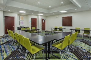 A conference room with a long table, green chairs, patterned carpet, and white walls. - Holiday Inn Express & Suites Lebanon-Nashville Area by IHG (Lebanon)