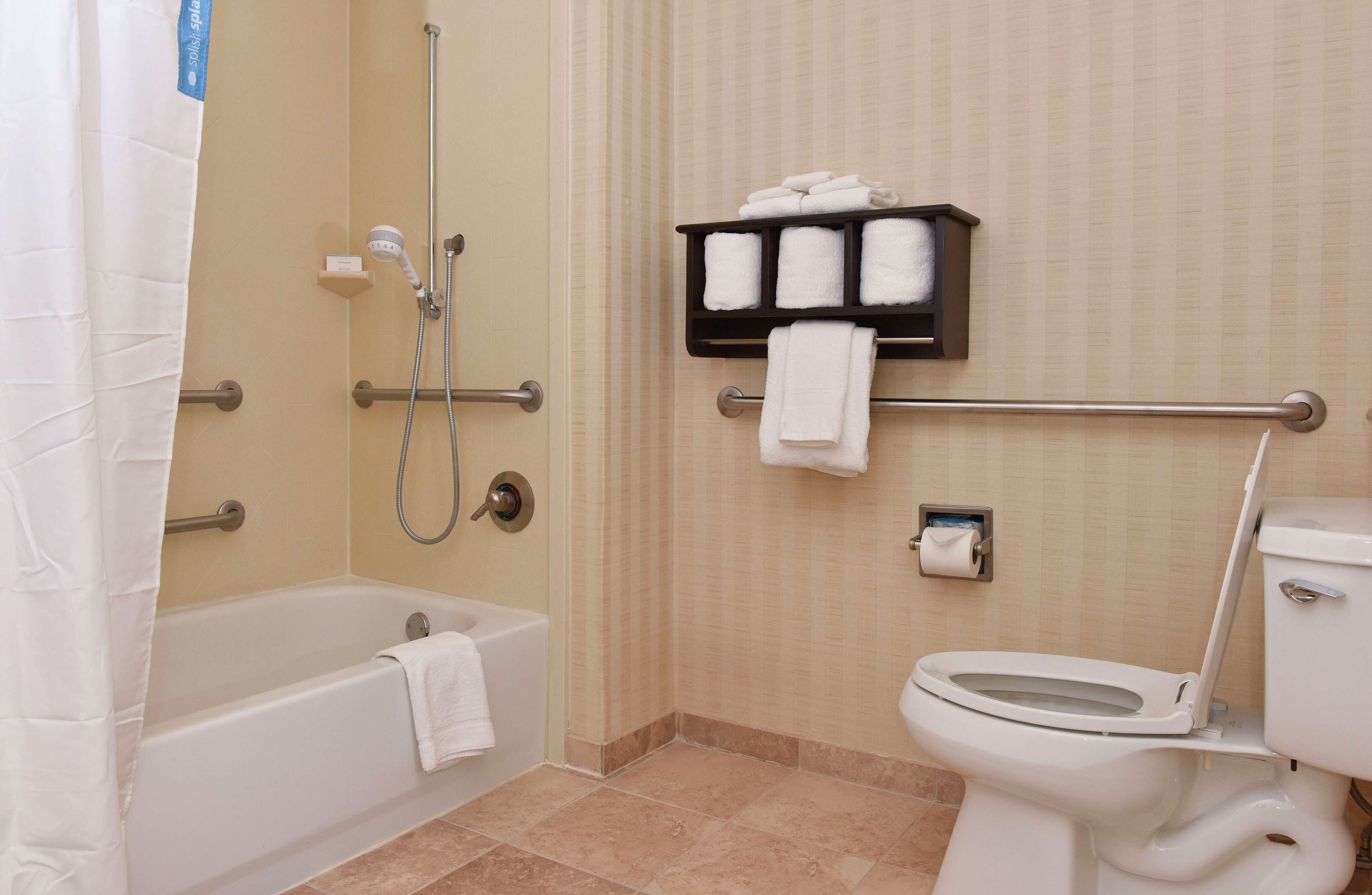 Une salle de bain équipée d’une baignoire, d’une douche, de toilettes et d’un porte-serviettes avec des serviettes.