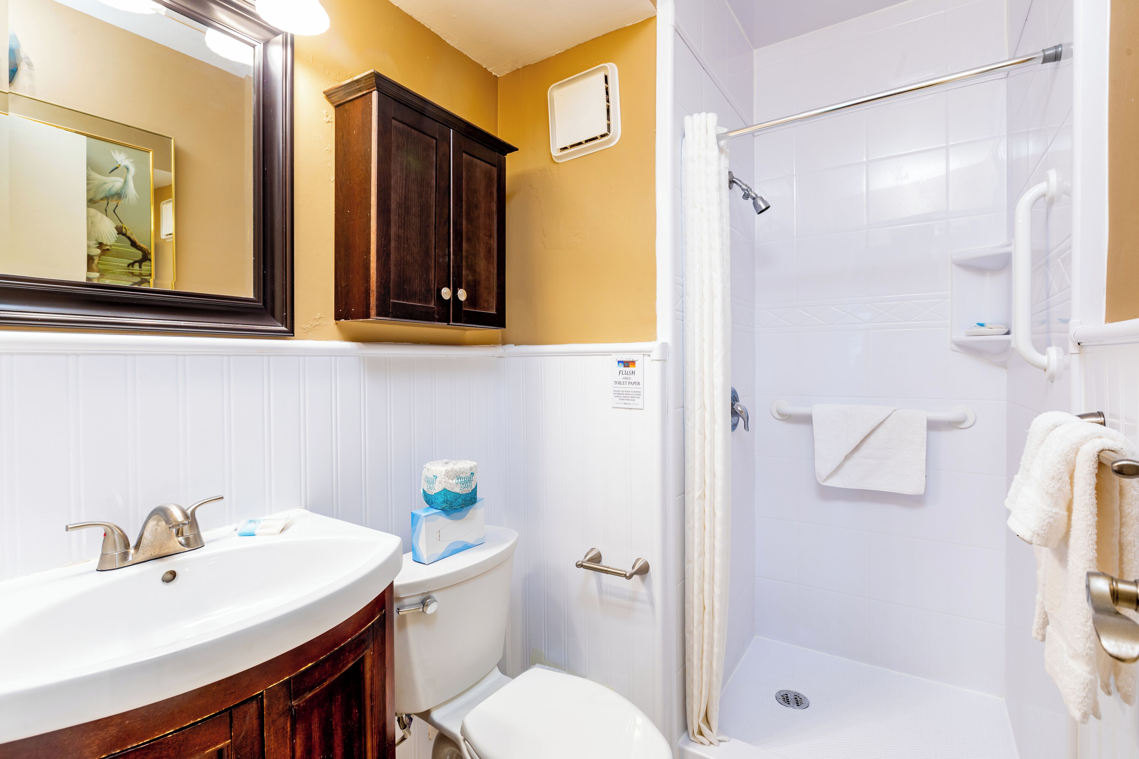A bathroom with a sink, toilet, and shower.
