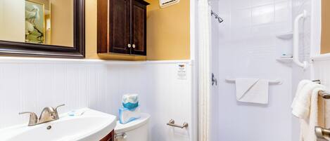 A bathroom with a sink, toilet, and shower.