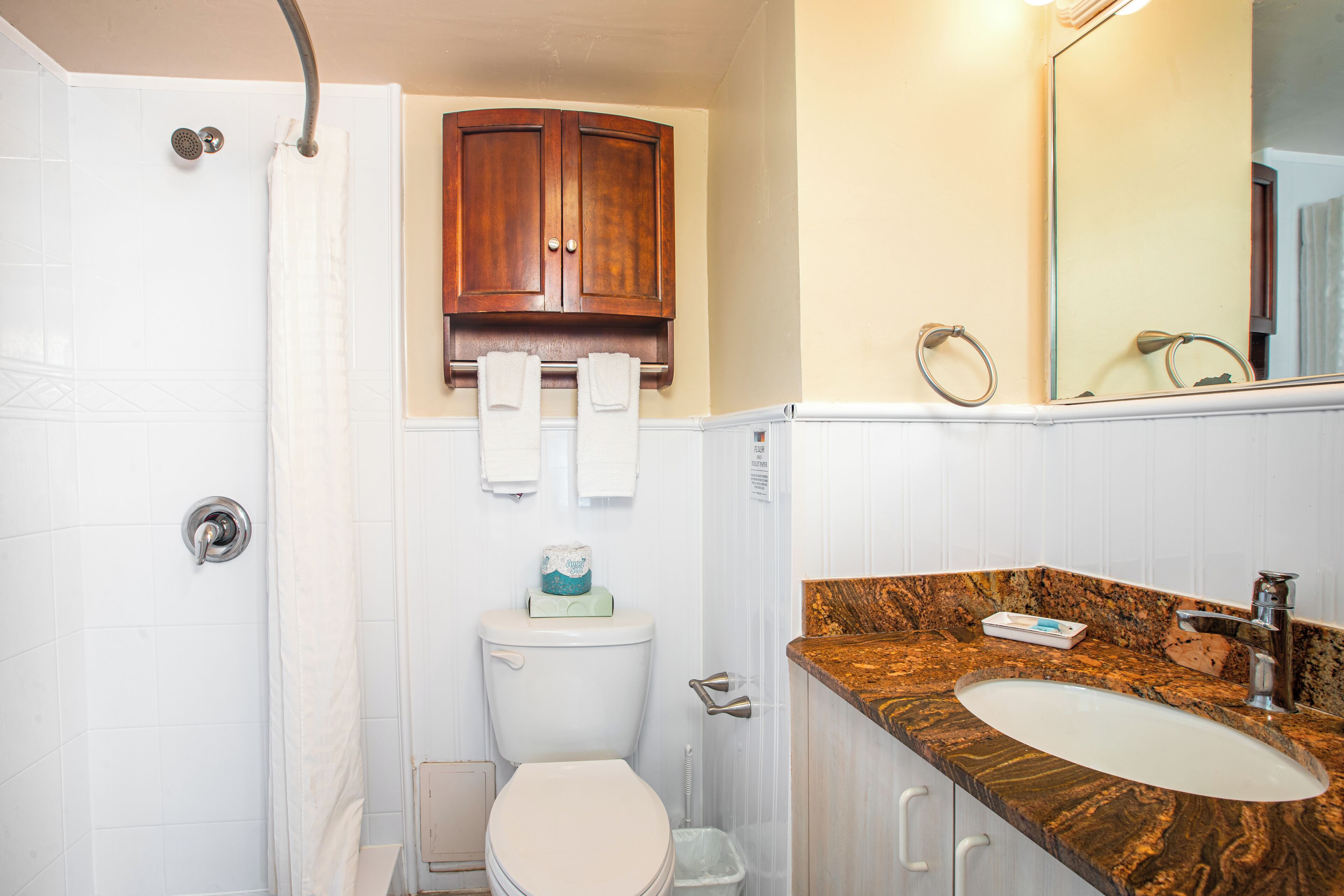 A bathroom with a shower, toilet, and sink.