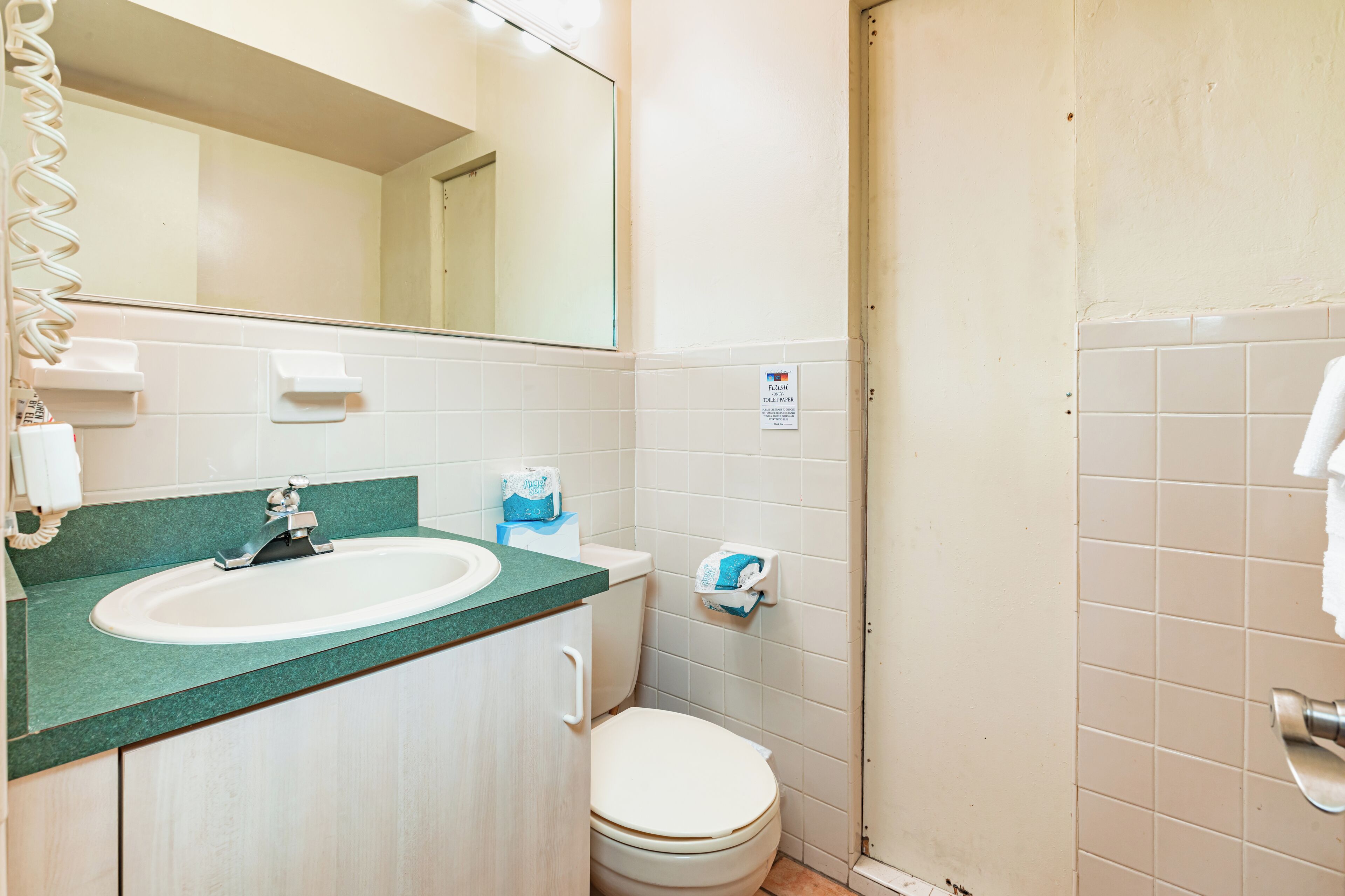 A bathroom with a sink, mirror, toilet, and a towel rack.