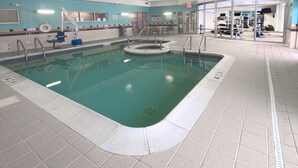 An indoor swimming pool with a tiled floor, a lifeguard chair, and a pool ladder. - SpringHill Suites by Marriott Albany-Colonie (Albany)