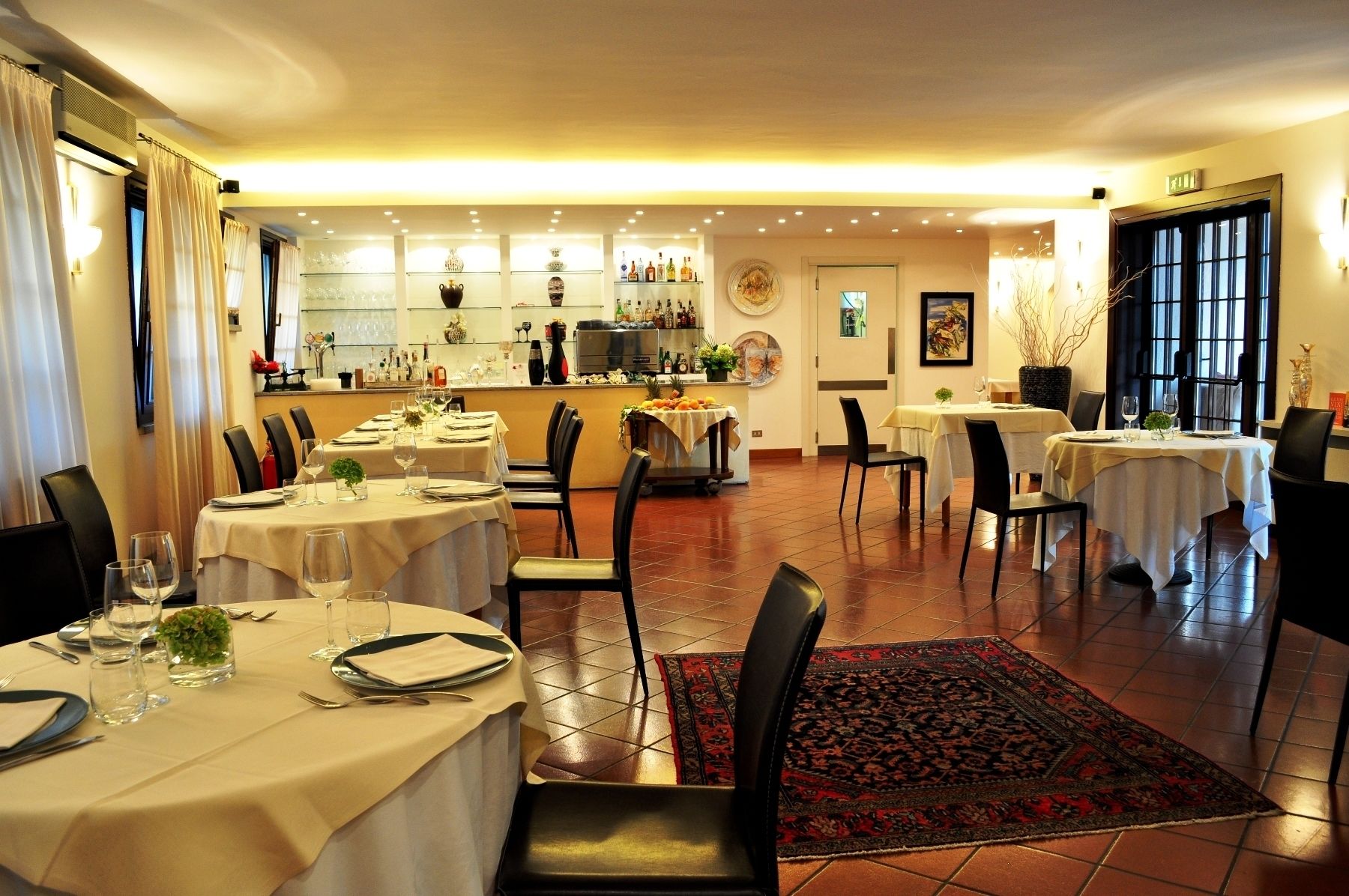 Een restaurant met verschillende tafels, stoelen en een bar.