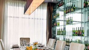 A well-set dining table with multiple chairs, wine glasses, plates, and a variety of appetizers. - Metropolitan Hotel Sofia, a member of Radisson Individuals (Sofia)