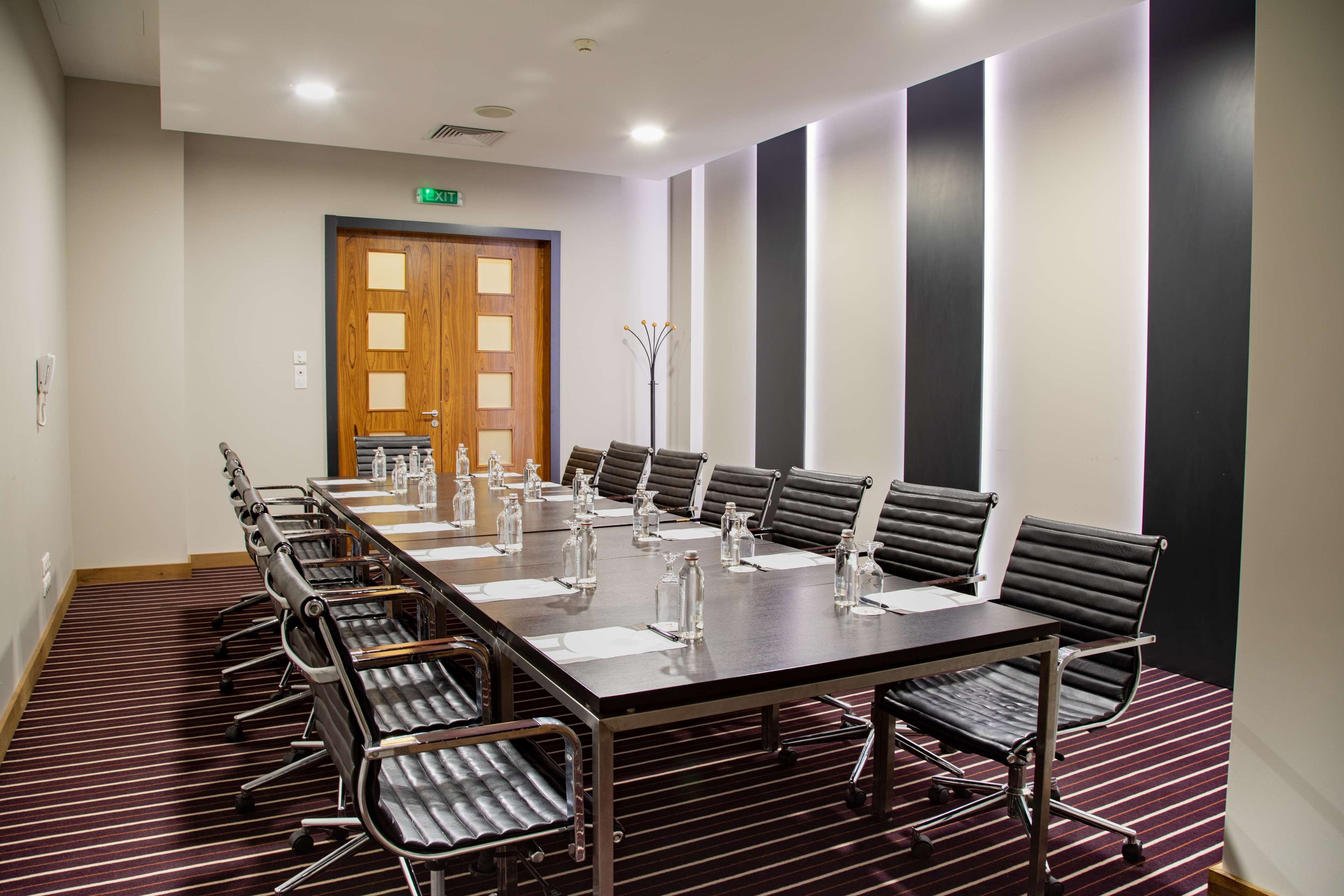 A conference room with a long table, chairs, and water bottles.